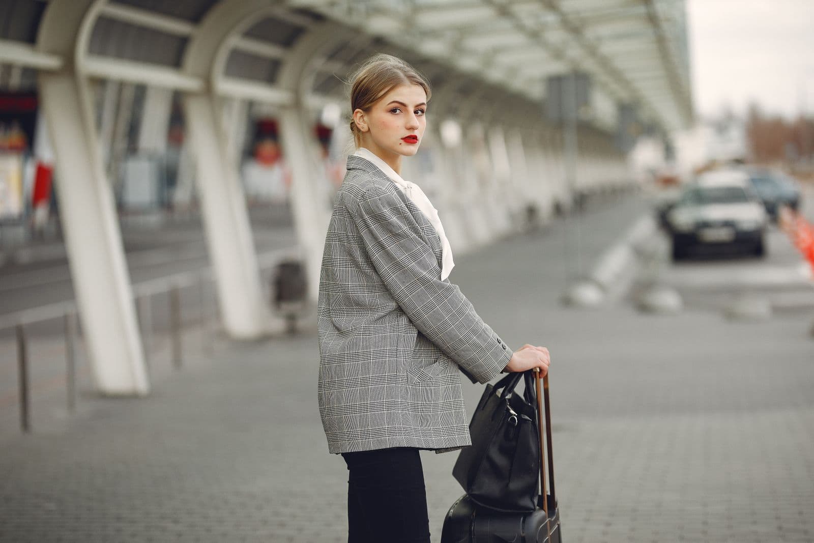 Voyageuse avec valise près d'un véhicule